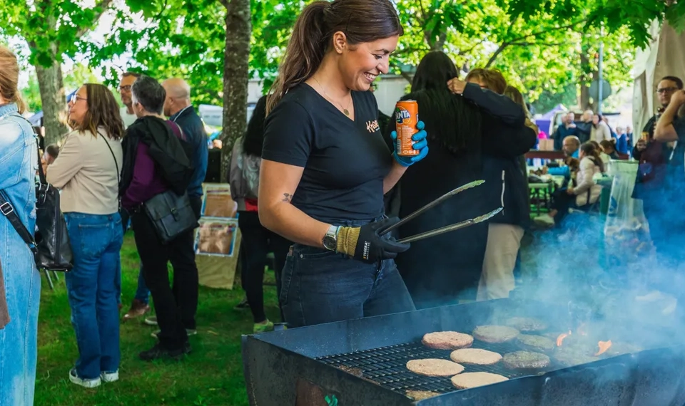 Kvinna som grillar under ett evenemang i en park