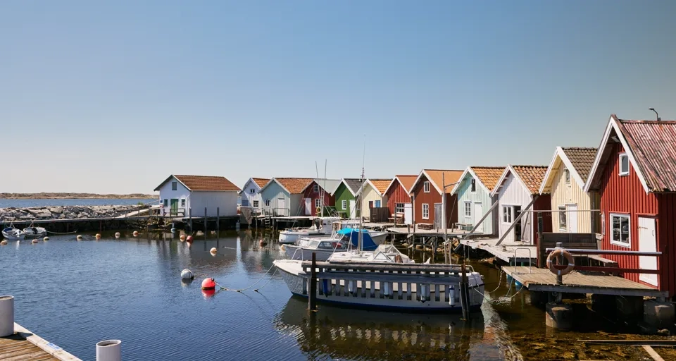 En rad med sjöbodar som ligger vid havet.