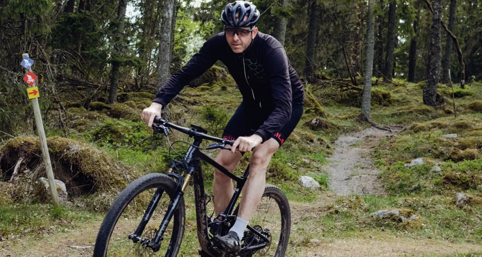 Ein Mann fährt auf einem Fahrrad einen Feldweg hinunter.