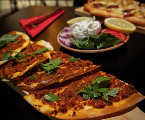 Ett bord med pizzor täckta av toppings.