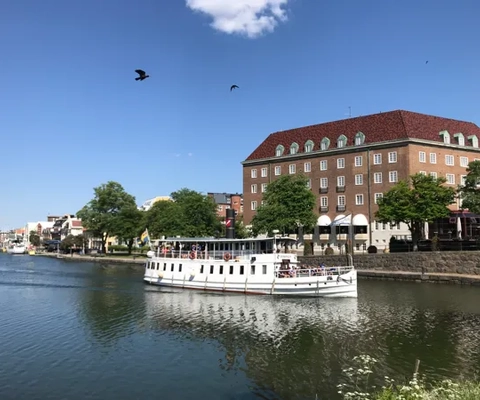 En stor vit båt som flyter på toppen av en flod.