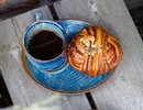 Blå fat med bullar och en blå kaffekopp med kaffe i.