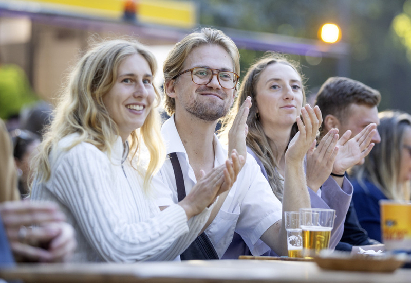 En grupp människor som sitter vid ett bord och klappar.
