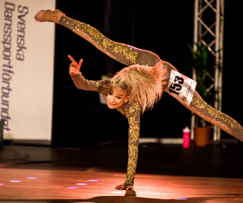 En kvinna som gör handstående på en scen.