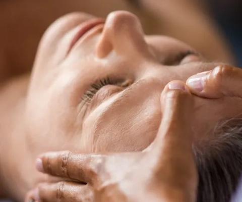 En kvinna får ansiktsmassage på ett spa.