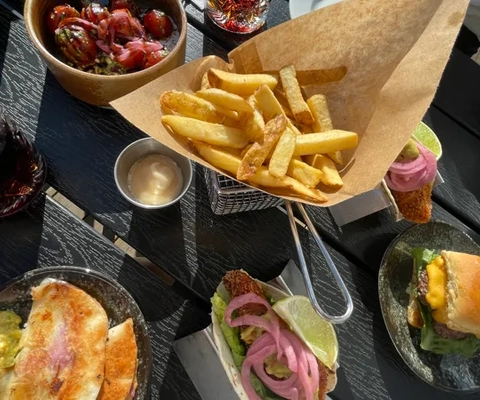 Ett bord med tallrikar med mat och en smörgås.