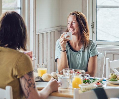 Kvinnor som äter frukost i en campingstuga.
