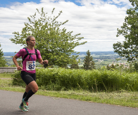 En kvinna som springer längs en gångväg i ett lopp.