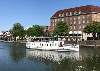En stor vit båt som flyter på toppen av en flod.