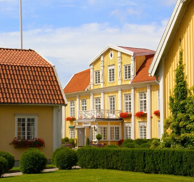 En rad gula hus med rött tak.
