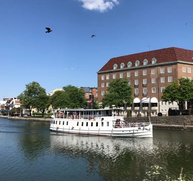 En stor vit båt som flyter på toppen av en flod.