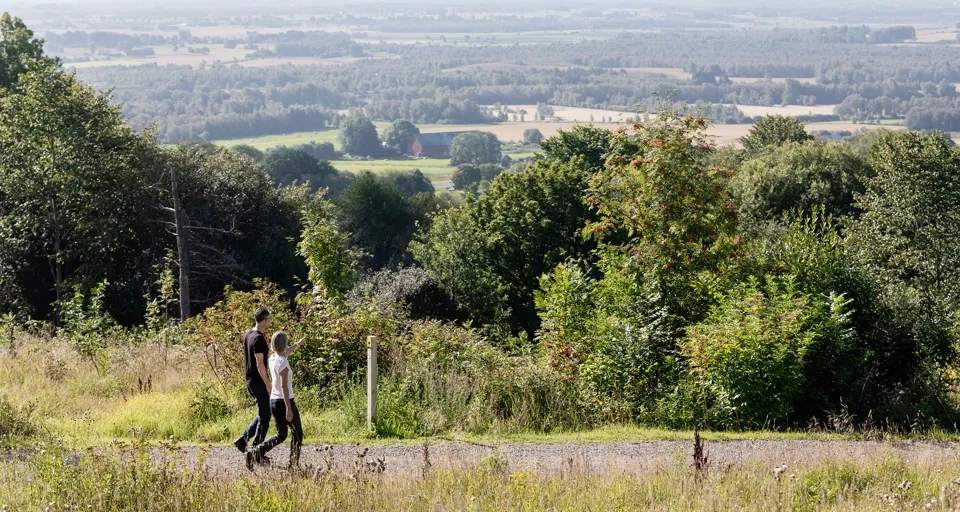 man och kvinna som vandrar på ett motionsspår. Vacker utsikt i bakgrunden.