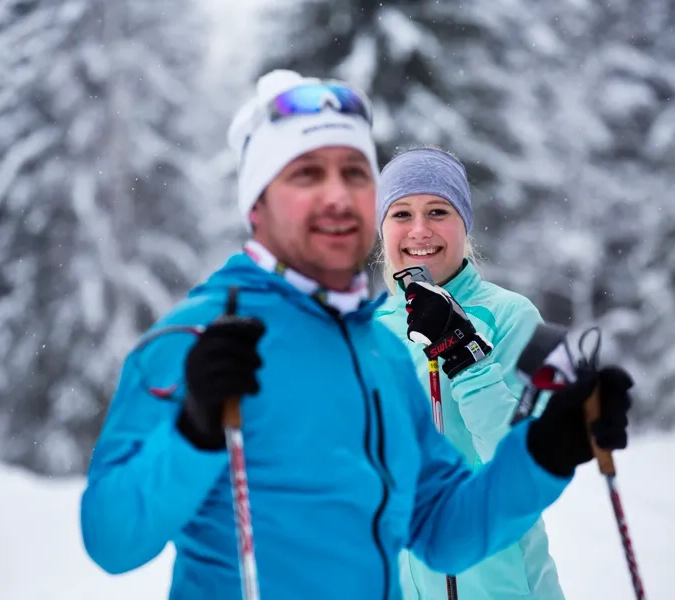 En man och en kvinna på skidor i snön.