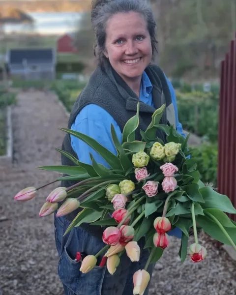 En kvinna som håller en bukett blommor i sina händer.