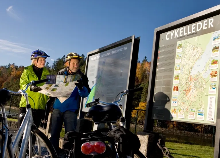 Några personer som står bredvid en cykel.