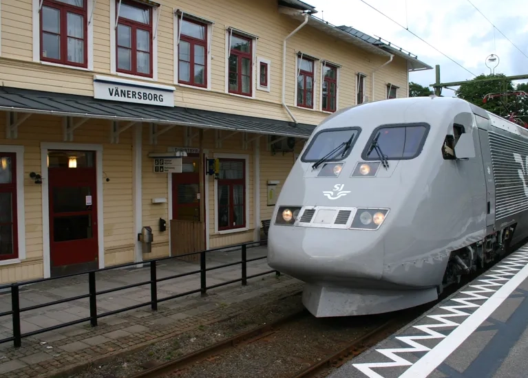 Ett silverfärgat tåg som rullar in på en tågstation.