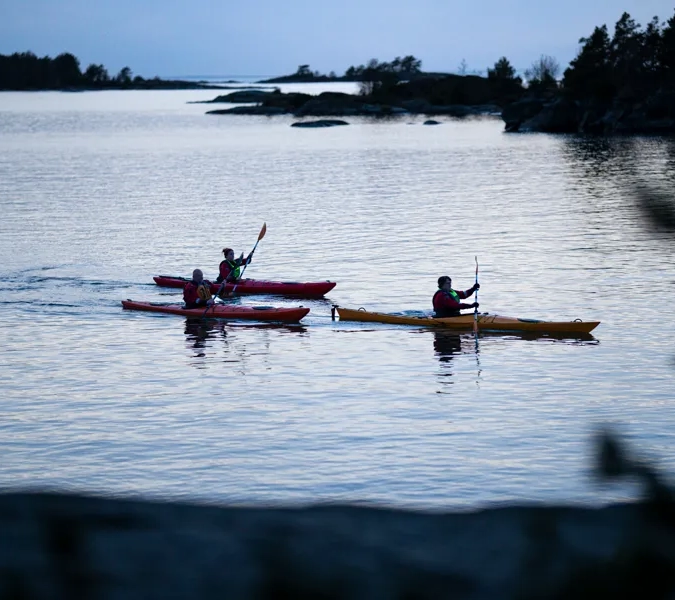 Two people in canoes paddling on the water.