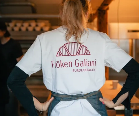 A woman standing in a kitchen with her hands on her hips.