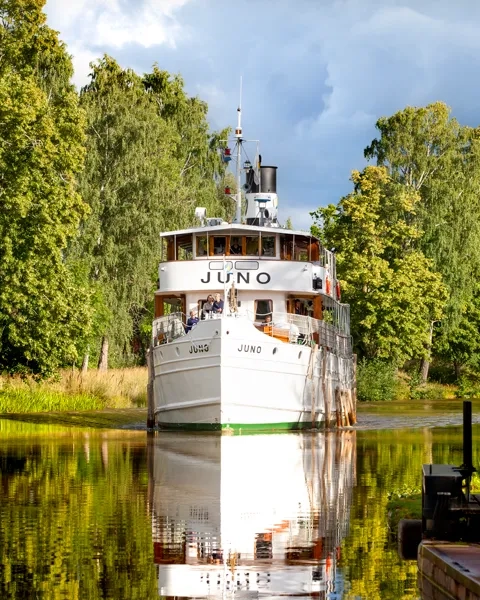 A large white boat floating on top of a lake.