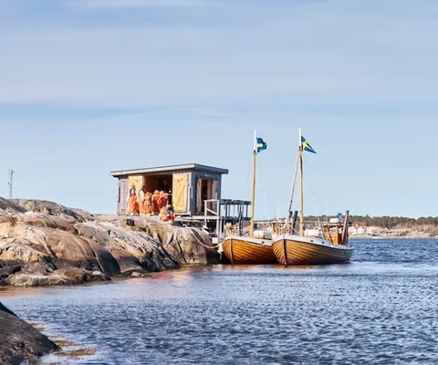Kastor Boat Trips träbåtar Pollux och Kastor förtöjda vid en sjöbod i skärgården