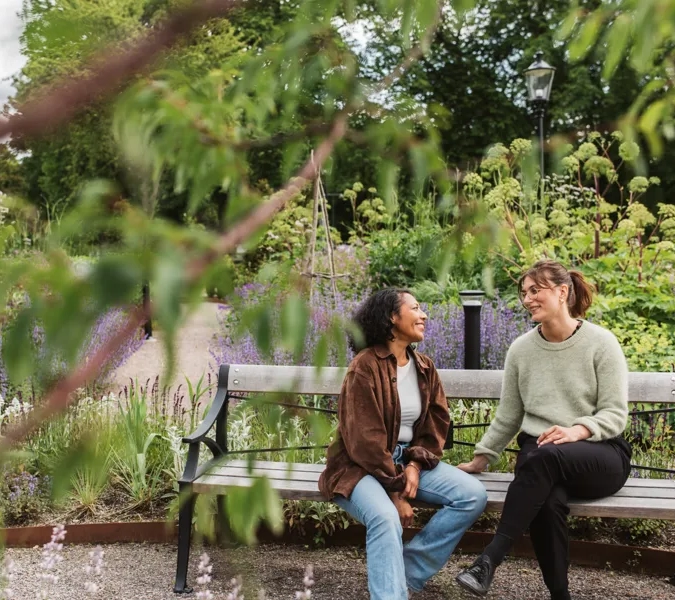 Några kvinnor sitter på en träbänk.