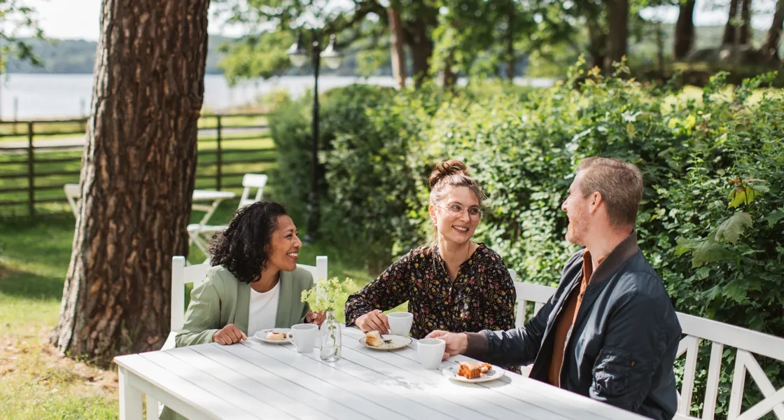 En grupp människor som sitter runt ett vitt bord.
