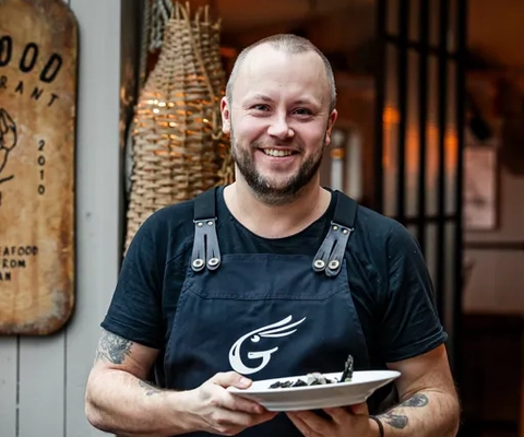 Servitör med tallrik på Göstas Fiskekrog