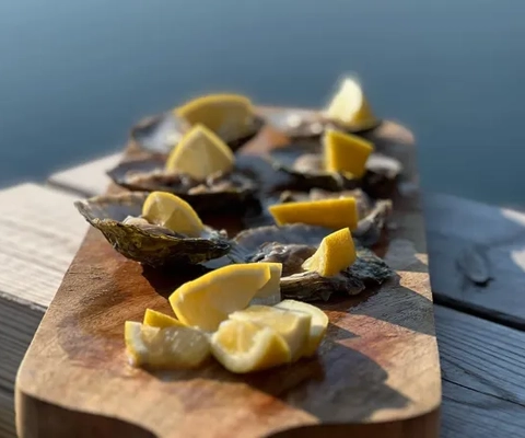 En skärbräda av trä med skivade citroner.