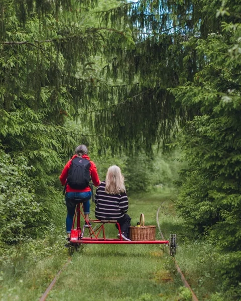 Två personer cyklar dressin.