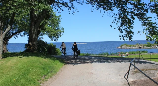 Några personer som cyklar på en grusväg.