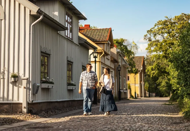 A man and woman walking down a cobblestone street.