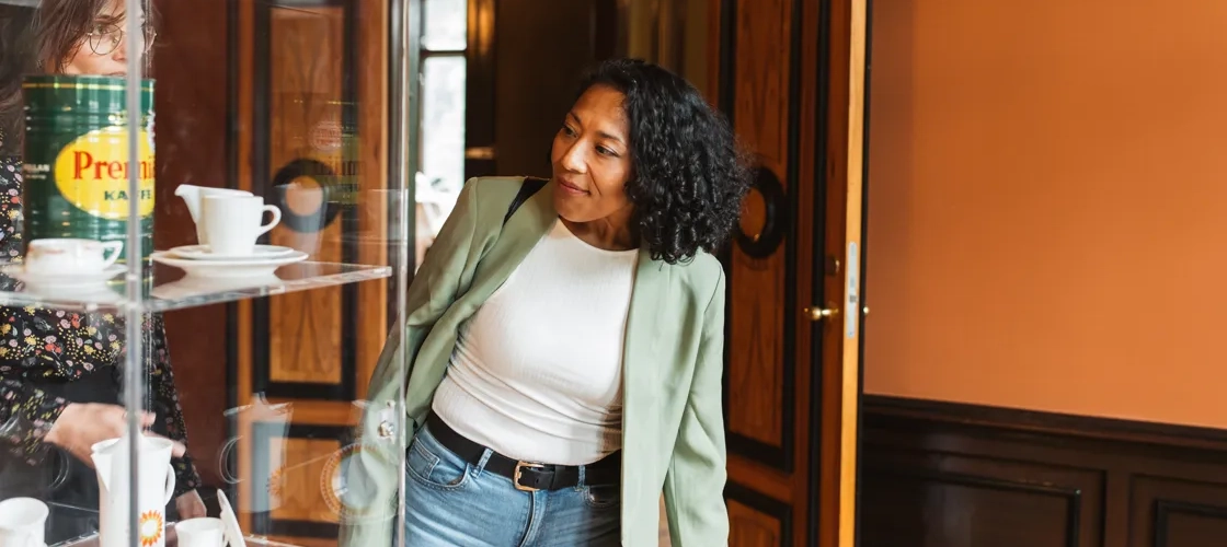 En kvinna står framför ett monter i en utställning.