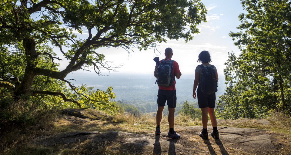 A couple of people standing on top of a hill.