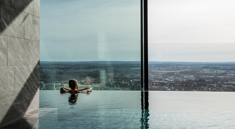 A woman in a swimming pool looking out a window.