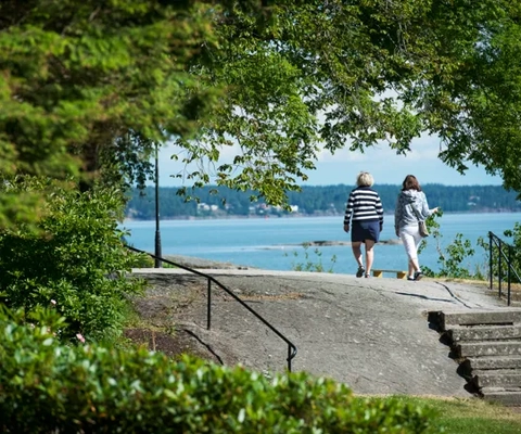 Två personer promenerar vid Vänerns vatten