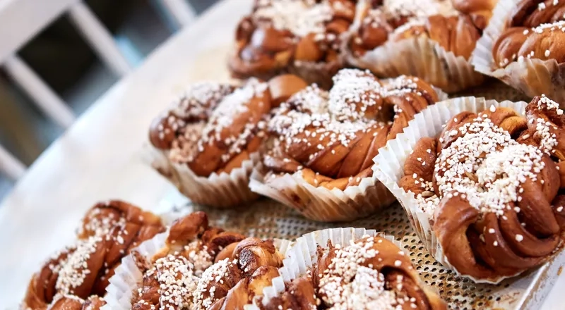 A table topped with lots of pastries covered in powdered sugar.