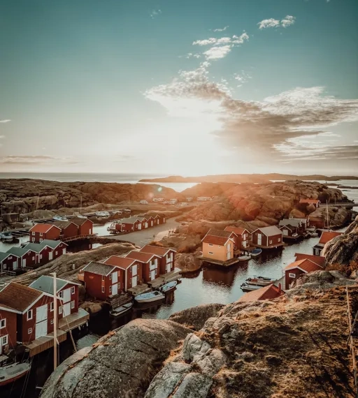 Vacker vy i solnedgång över Smögenbryggans fiskebodar, hus och klippor, Hotell Smögens Hafvsbad