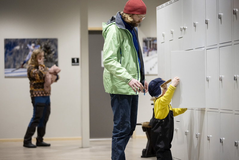 A father and son open a locker in the changing room.