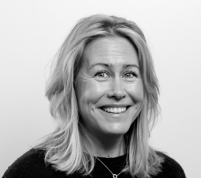 A black and white photo of a smiling woman.