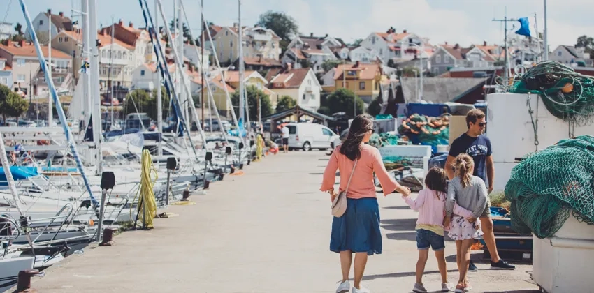 Barnfamilj promenerar ute på Torskholmen, Strömstads fiskehamn.