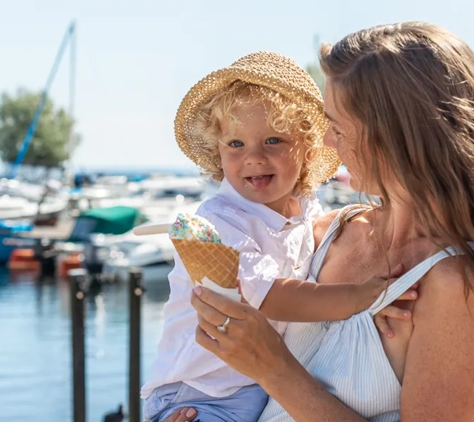 Eine Frau hält ein kleines Kind in der Nähe eines Gewässers.