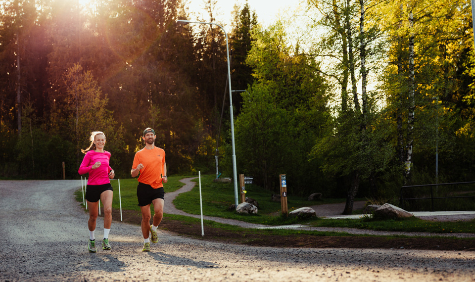 Två personer som springer på ett grusat motionsspår
