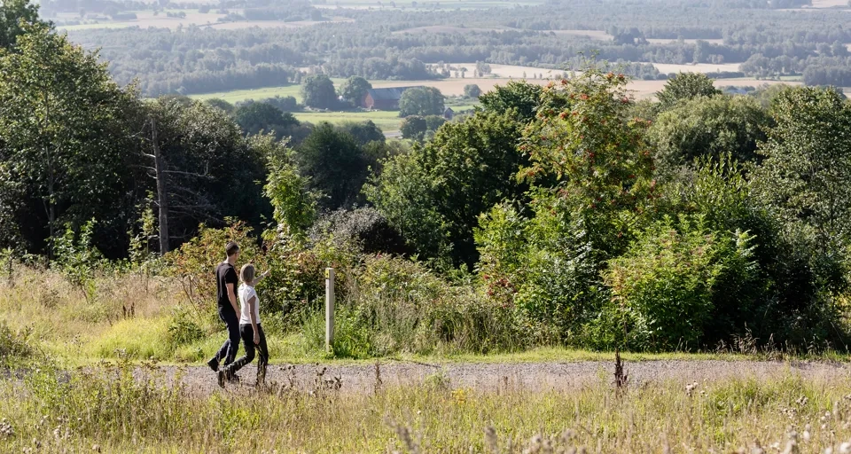 man och kvinna som vandrar på ett motionsspår. Vacker utsikt i bakgrunden.