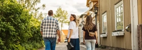 Eine Gruppe von Menschen, die eine Kopfsteinpflasterstraße entlanggeht.