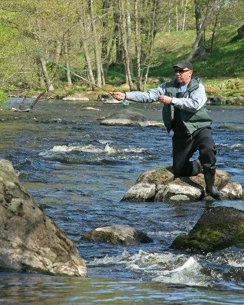 En man flugfiskar i ån Tidan vid Baltak