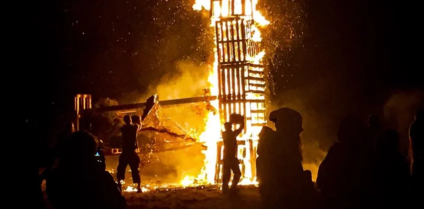 En grupp människor som står runt en påskefyr.