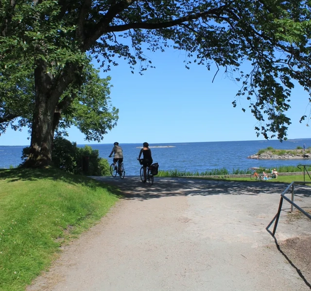 Några personer som cyklar på en grusväg.