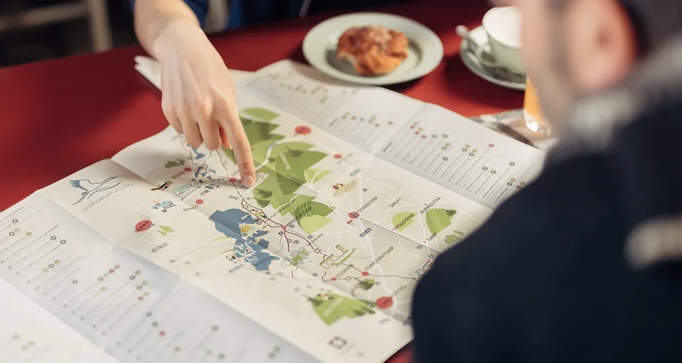 Två människor planerar sin vandring över en fika.