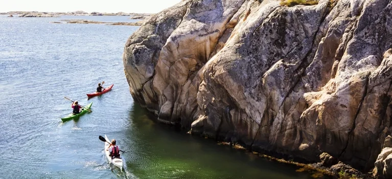 To personer i kanoer padler på vannet.