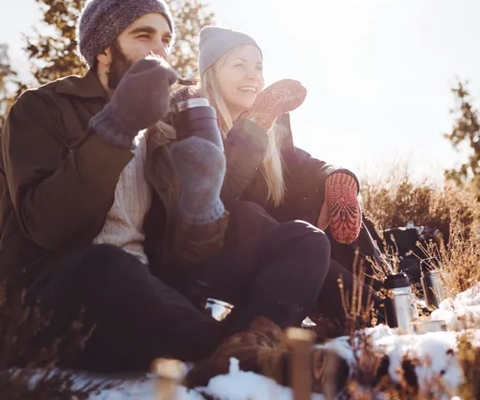 Vänner som tar en paus under vintervandring i skogslandskap i Västsverige.